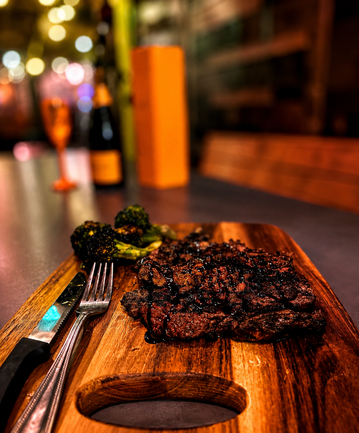 Grilled ribeye steak plated on a wooden board at Brick Bistro